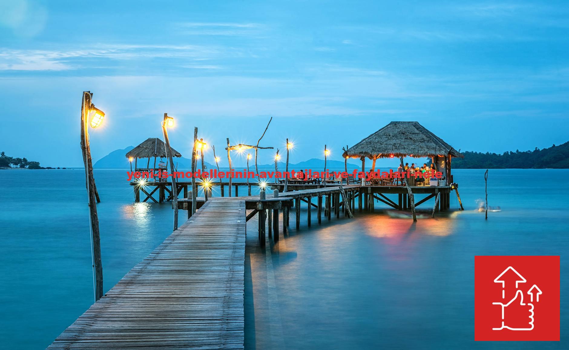 Illuminated pier and bungalow on a tranquil tropical sea at twilight.