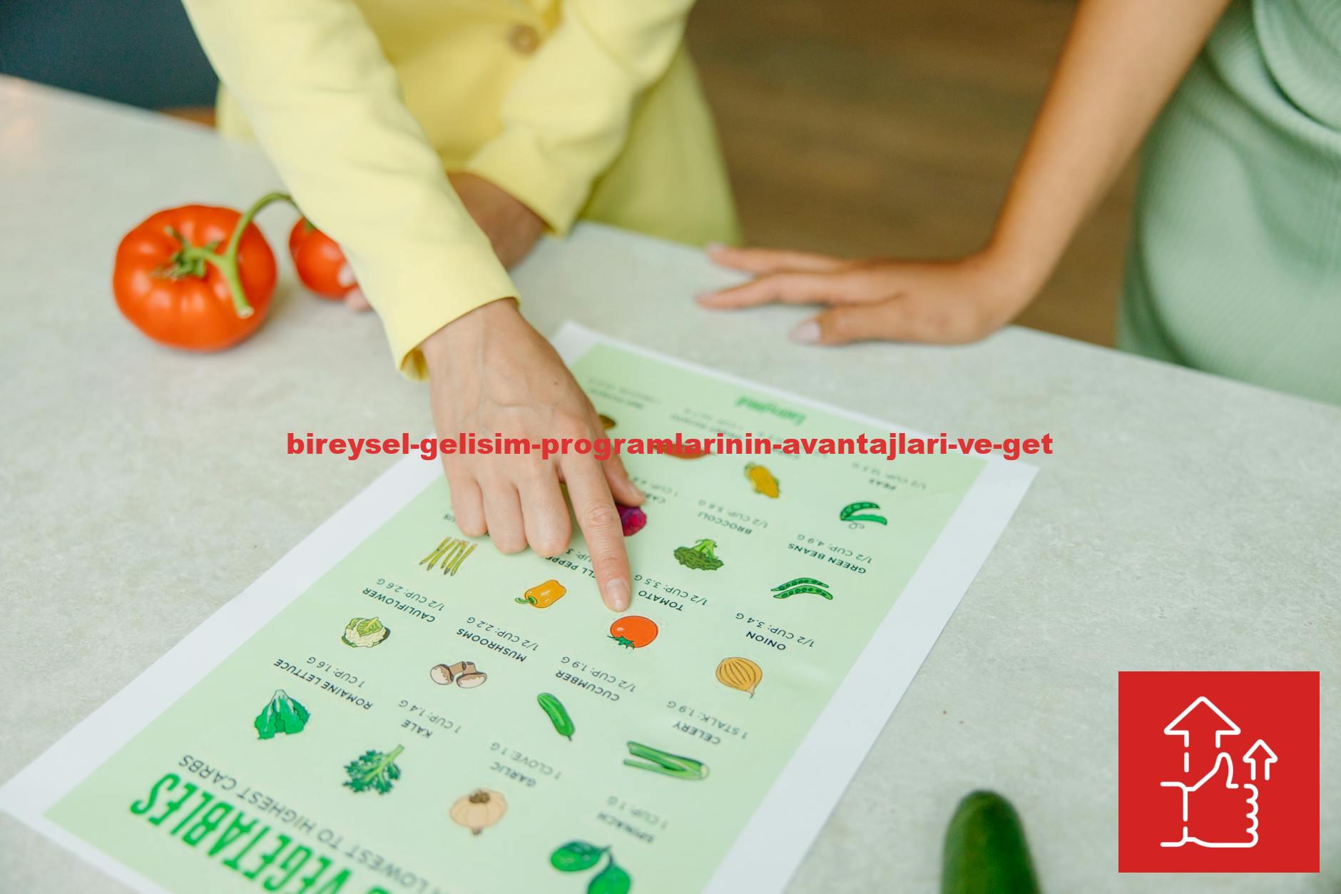 Close-up of hands pointing to a vegetable nutrition chart with fresh tomatoes on the table.