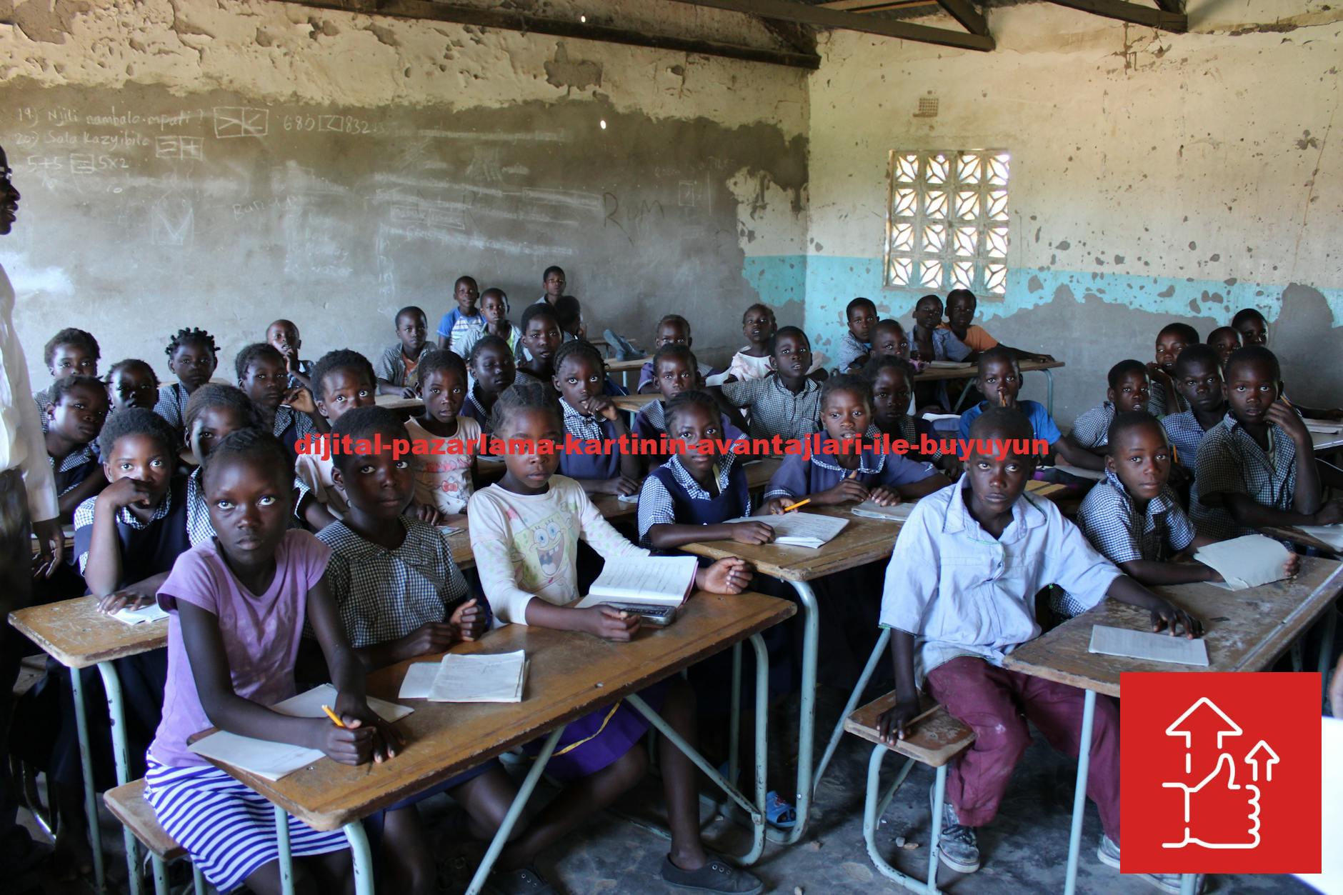 A group of children in a classroom in Zambia focused on their studies.