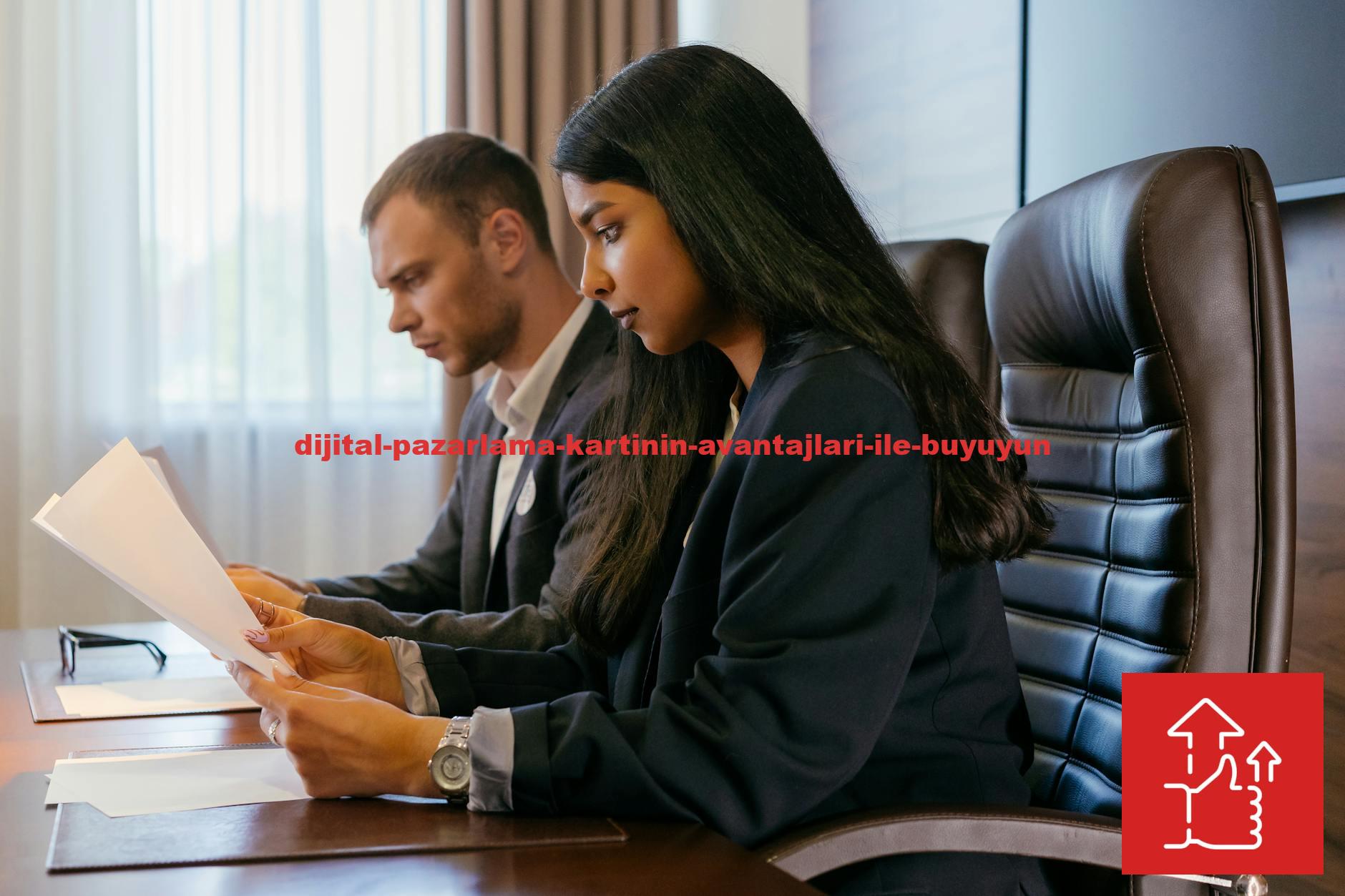Two professionals reviewing documents in an office setting, showcasing teamwork and diversity.