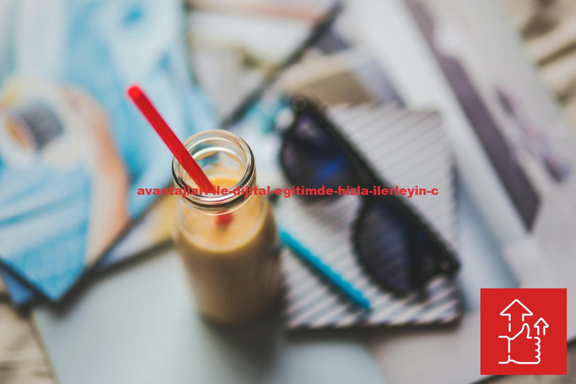 A refreshing smoothie with red straw on an artistic desk setup featuring sunglasses and stationery.