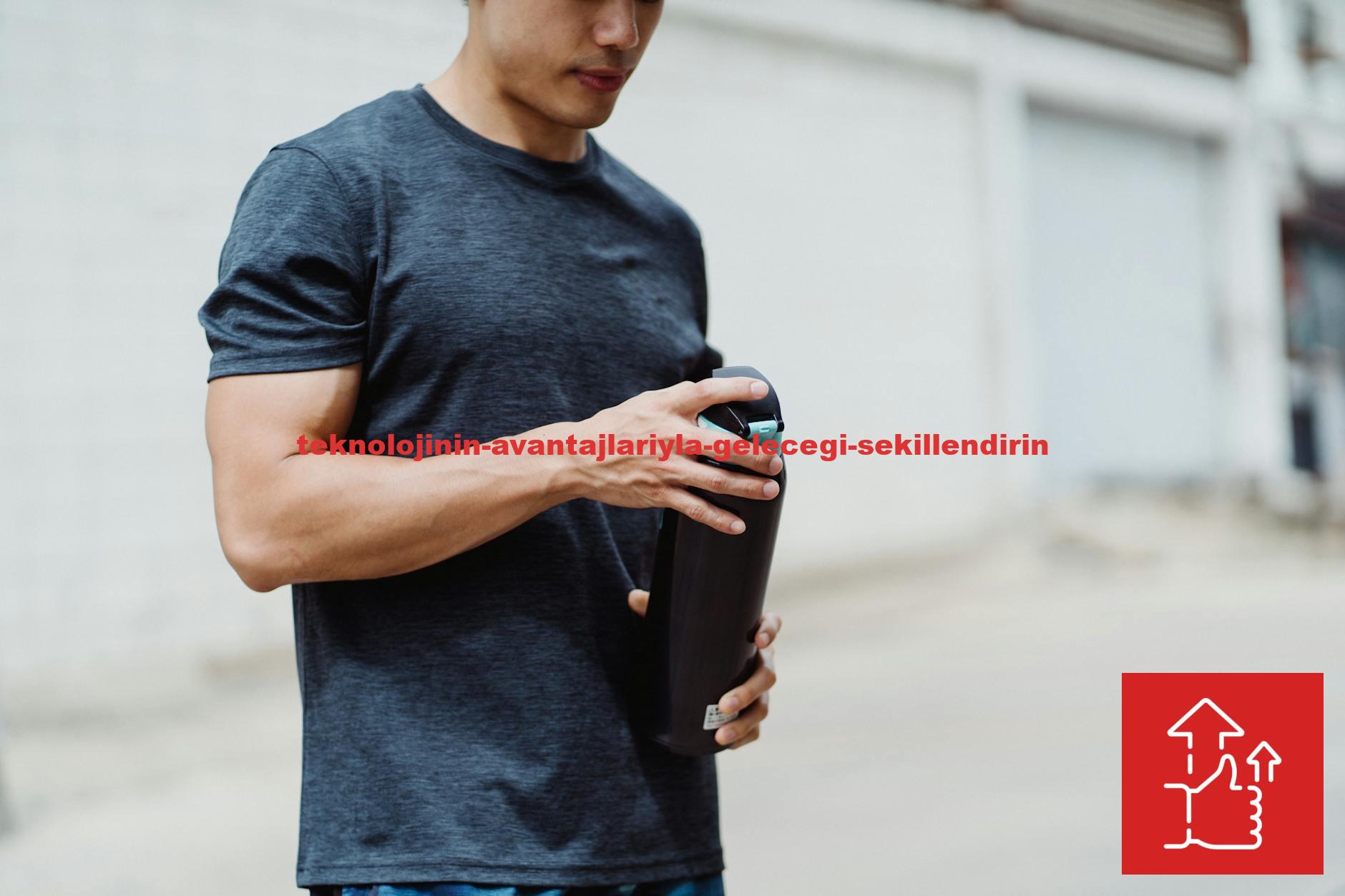 Young man holding a water bottle during his street workout session outdoors.