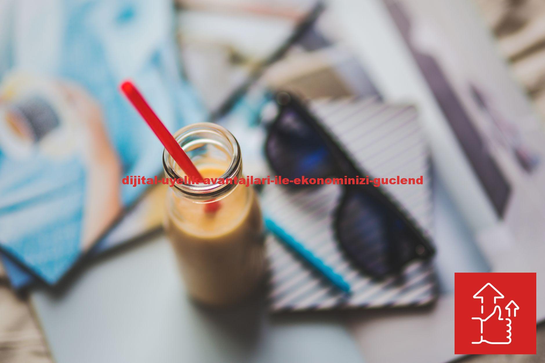 A refreshing smoothie with red straw on an artistic desk setup featuring sunglasses and stationery.